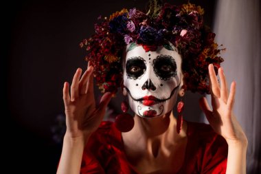 Tatil da de los muertos için kafasına halloween kafatası ve çiçekler için makyaj ile bir kızın portresi