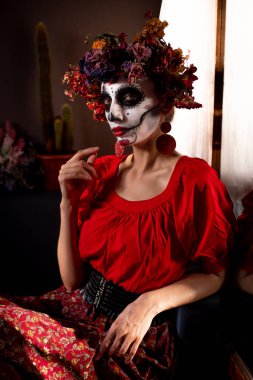 Tatil da de los muertos için kafasına halloween kafatası ve çiçekler için makyaj ile bir kızın portresi