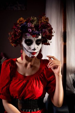 Tatil da de los muertos için kafasına halloween kafatası ve çiçekler için makyaj ile bir kızın portresi
