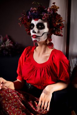 Tatil da de los muertos için kafasına halloween kafatası ve çiçekler için makyaj ile bir kızın portresi