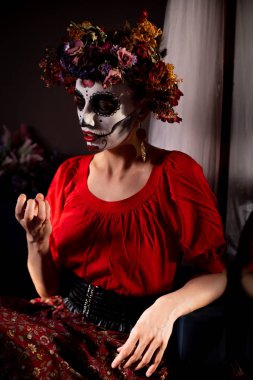 Tatil da de los muertos için kafasına halloween kafatası ve çiçekler için makyaj ile bir kızın portresi
