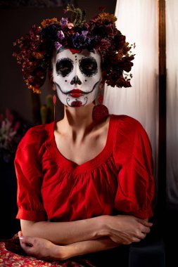 Tatil da de los muertos için kafasına halloween kafatası ve çiçekler için makyaj ile bir kızın portresi