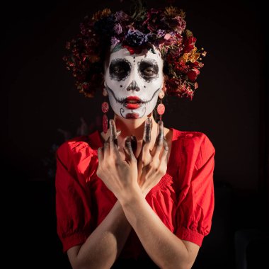 Tatil da de los muertos için kafasına halloween kafatası ve çiçekler için makyaj ile bir kızın portresi