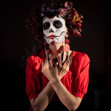 Tatil da de los muertos için kafasına halloween kafatası ve çiçekler için makyaj ile bir kızın portresi