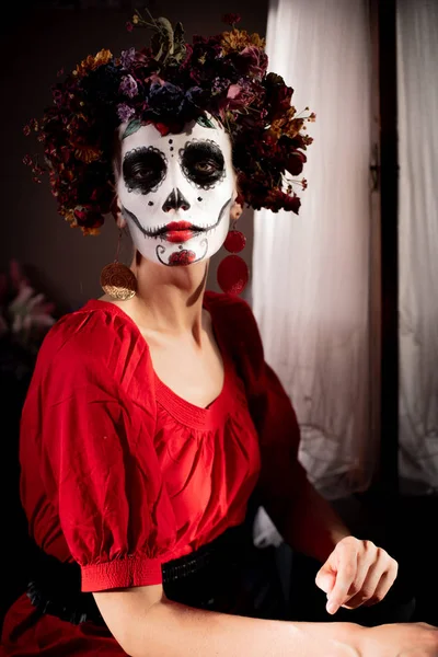 Tatil da de los muertos için kafasına halloween kafatası ve çiçekler için makyaj ile bir kızın portresi