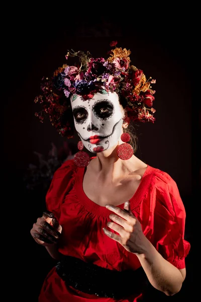 Tatil da de los muertos için kafasına halloween kafatası ve çiçekler için makyaj ile bir kızın portresi