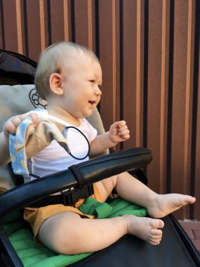 Bebek arabasındaki bebek eco çantasıyla oynuyor