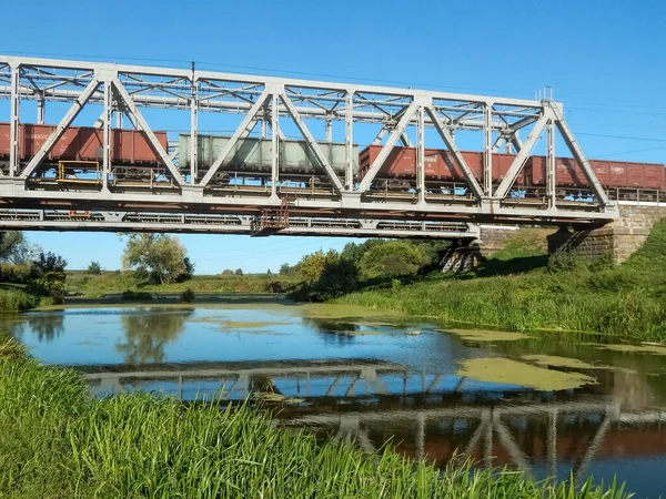 Tren Mercancías Viaja Puente Ferroviario Metal Reflejos Río —  Fotos de Stock