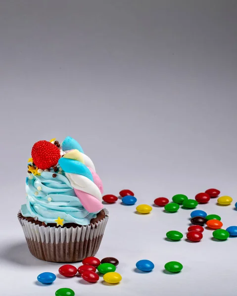 Marshmallow detaylarıyla mavi ve pembe renkli kekler. Sonsuz beyaz ve gri bir arkaplanda izole edilmiş. Boşluğu kopyala.