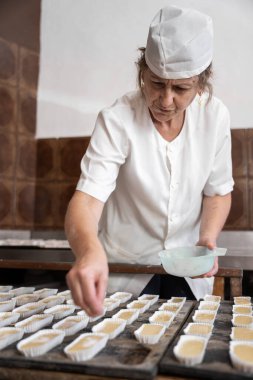 Kek kalıbına şeker ekleyen fırıncı kadın