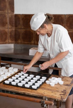 Kek kalıplarını düzenleyen fırıncı kadın.