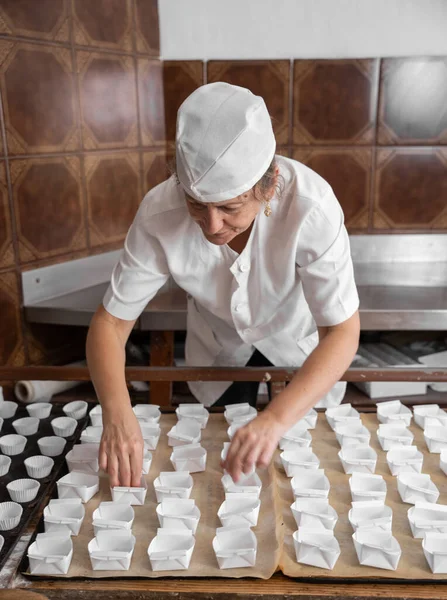 Kek kalıplarını düzenleyen fırıncı kadın.