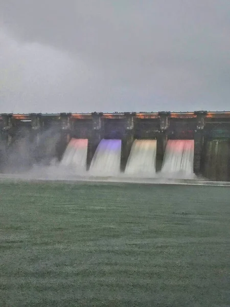 从高压电和五彩缤纷的灯光下从大坝中流出的水 大坝的4个闸门打开 — 图库照片