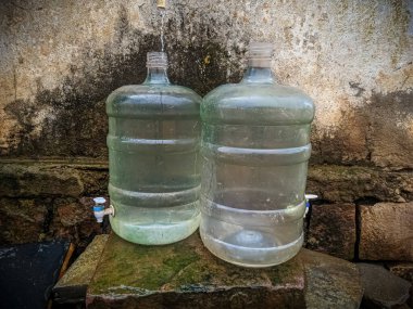 Islak bir taşın üzerinde iki su kabı..