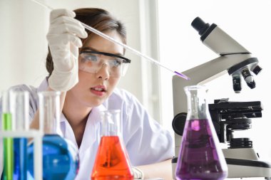 Kadın araştırma bilim adamı kullanarak Micropipette doldurma Test tüpleri laboratuvarda mı.