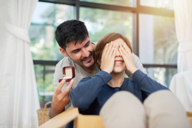 Genç adam onun güzel kız arkadaşı ile nişan yüzüğü yeni hareketli ev zamanımda şaşırtıcı.