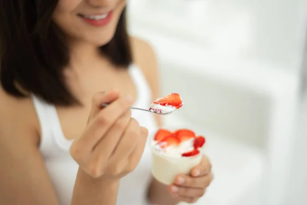 Young Asian Beautiful woman eating strawberries with yogurt on white background at home. Smiling Face.