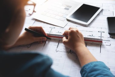 Planları çizim çizim ile çalışan kadın tasarımcı.