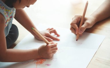 Çizim birlikte anne ve kızı ellerini kapatın. Çocuk ile eğleniyor anaokulu öğretmeni.