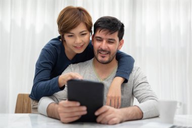 Tablet ve vakit birlikte hafta sonu evlerinde laptop ile mutlu genç çift.