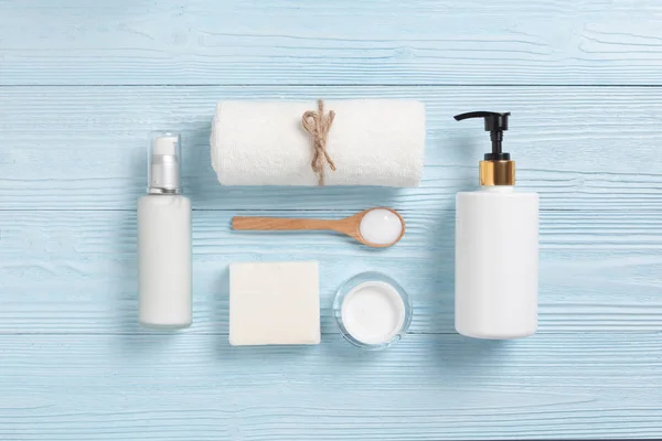 Top view of Cosmetic Spa products on blue wood background. Towel, cream bottles, wooden spoon, soap with Copy space.