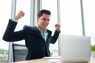 Başarılı bir iş adamı ile silah kadar dizüstü bilgisayarda çalışırken kutluyor.