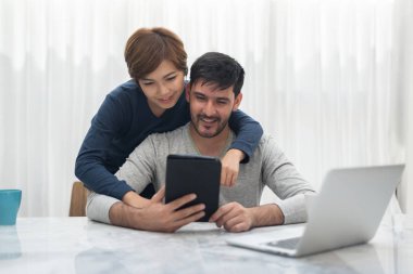 Tablet ve vakit birlikte hafta sonu evlerinde laptop ile mutlu genç çift.