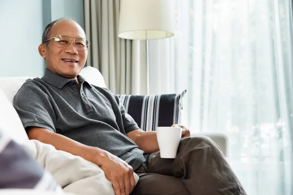 Boldog Ázsiai Idősebb Ember Kanapén Gazdaság Csésze Kávét Házában Mosolygó — Stock Fotó