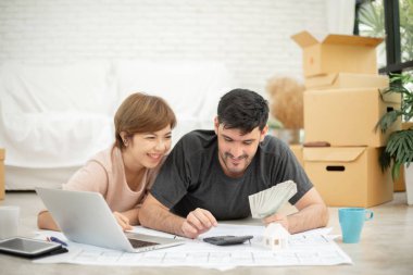 Para tutan ve ev taşıma kendi bütçe hesaplama dizüstü bilgisayar ile mutlu genç çift.