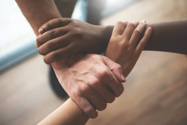 Bovenaanzicht van multi-etnische zakenmensen die hun handen samen houden — Stockfoto