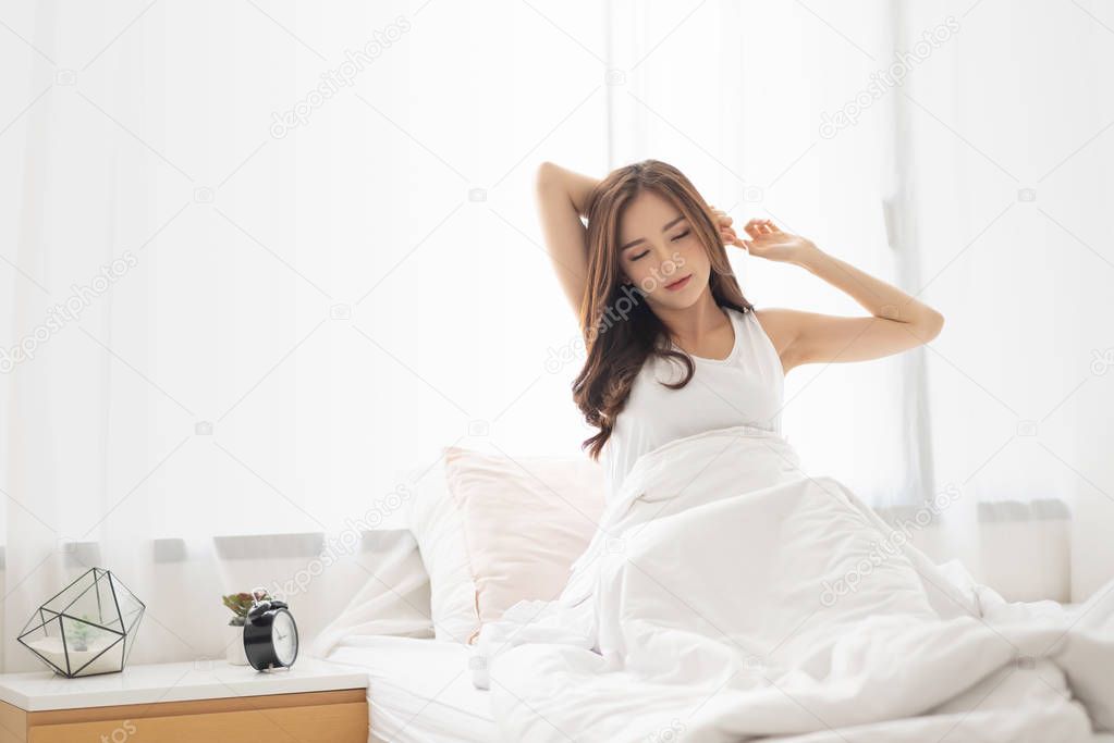 Beautiful Female is waking up in her bed on morning.