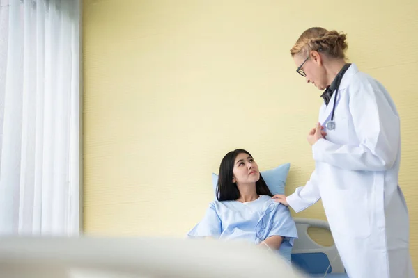 Senior mujer doctor tranquilizador asiático mujer paciente . — Foto de Stock