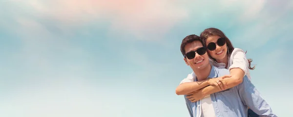 Casal usa óculos de sol se divertindo no céu azul e na praia . — Fotografia de Stock