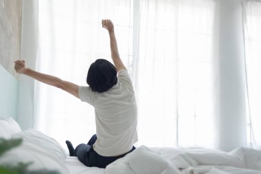 Genç adam sabahın erken saatlerinde kollarını germe