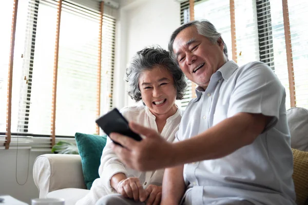 Heureux asiatique senior couple à l'aide de smartphone . — Photo