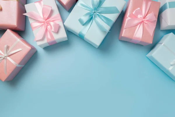Вид зверху на рожеві та сині подарункові коробки на синьому ізольованому фоні — стокове фото