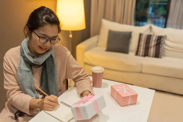 Aziatische mooie vrouw in trui en wollen sjaal is het schrijven van som — Stockfoto