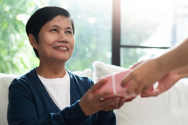 Fille donne une boîte-cadeau rose à la mère asiatique . — Photo