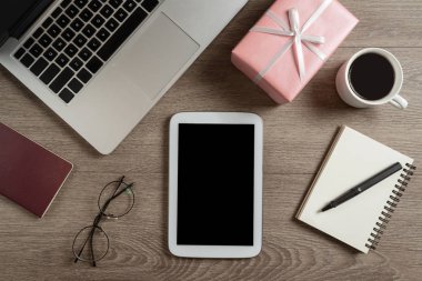 Dijital tabletin üst görüntüsü, pembe hediye kutusu, pasaport, gözlük,