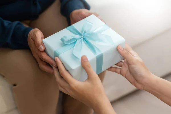 La hija le está dando una caja de regalo azul a su madre — Foto de Stock