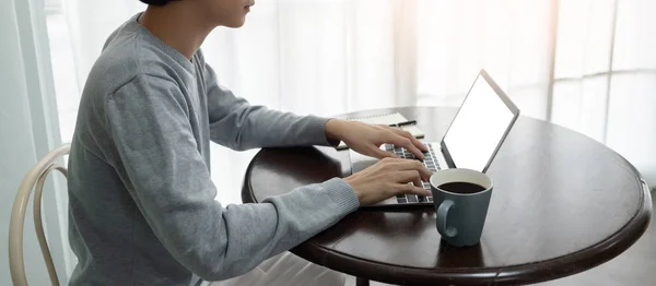 Asiático Jovem homem em suéter está usando computador portátil . — Fotografia de Stock