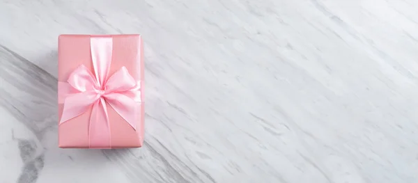 Caixa de presente rosa sobre fundo de mármore branco . — Fotografia de Stock