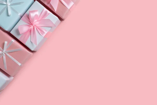 Bunte Geschenkboxen an der Ecke auf rosa Hintergrund — Stockfoto