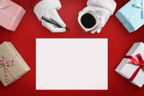 Santa Claus manos está escribiendo objetivos y hacer listas en un pa en blanco —  Fotos de Stock