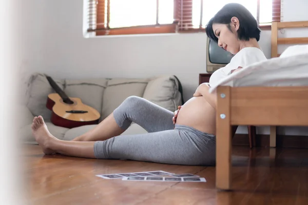 Mulher Grávida Asiática Sentada Chão Perto Sua Cama Tocando Sua — Fotografia de Stock