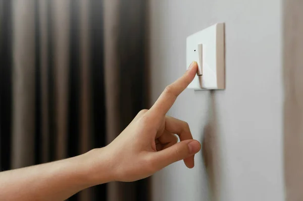 关闭女性手指是关闭照明开关在家里 复制空间 — 图库照片