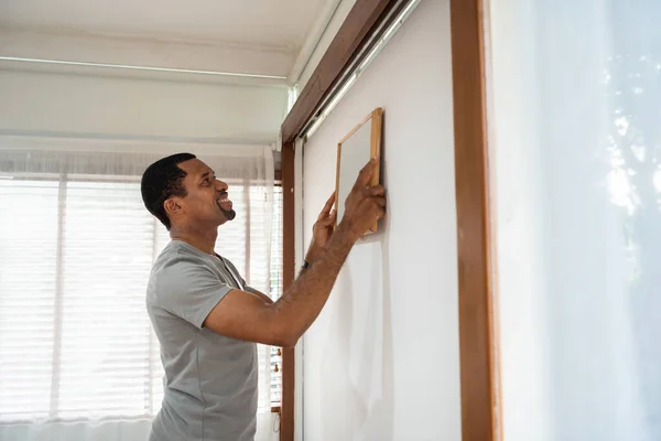 Afro Amerikaanse Man Houdt Zet Fotolijstje Muur Thuis Happy Smiling — Stockfoto