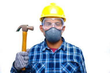 Çekiç tutarken güvenlik kaskı, maske, gözlük ve eldiven takan adamın fotoğrafı. İş yeri konseptinde güvenlik önce gelir