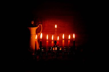 Hanukkah is a Jewish holiday. Burning Chanukah candlestick with candles. jug of oil. Chanukiah Menorah clipart