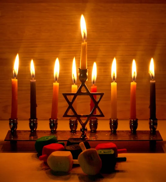 Chanukka är en judisk helgdag. Brinnande Chanukah ljusstake med levande ljus. Chanukiah Menorah. dreidel, savivon — Stockfoto